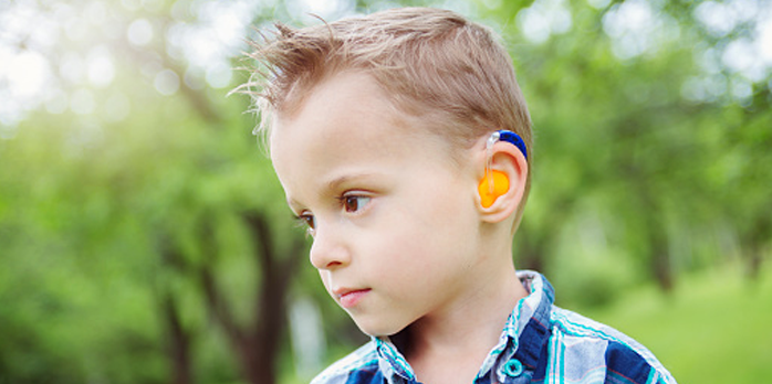 Boy wearing a hearing aid set.